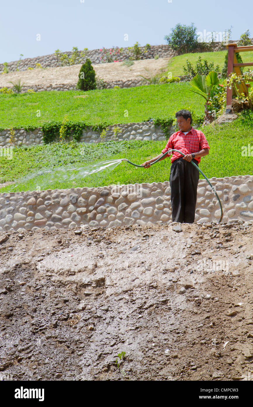Lima Peru,Barranco,Bajada de los Banos,quartier,flanc de coteau,jardin terrasse,pelouse,homme hispanique hommes adultes hommes,tuyau,eau,pulvérisation,saleté,sol,roc Banque D'Images