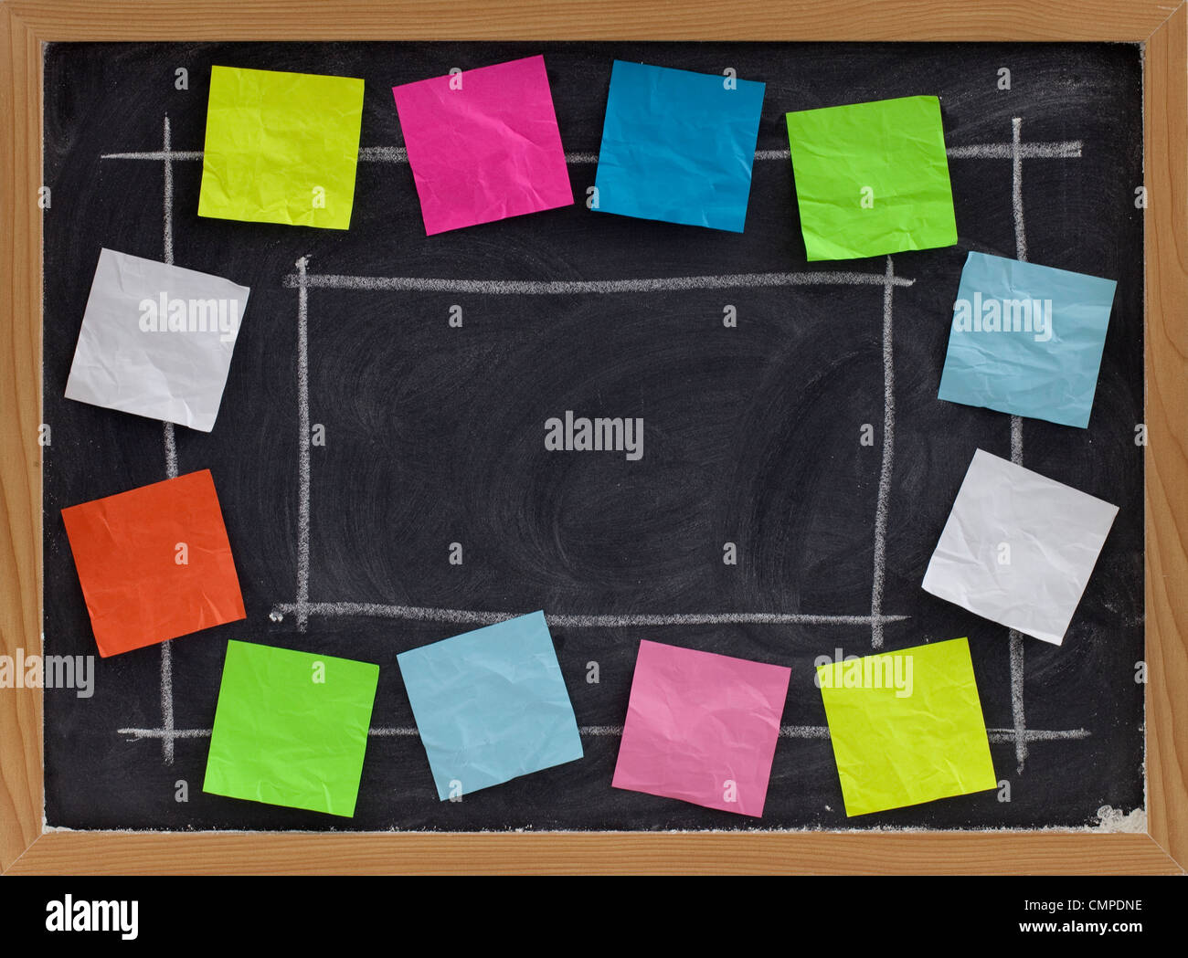 L'espace de copie sur tableau noir avec craie blanche entourée de texture vierge coloré sticky notes Banque D'Images