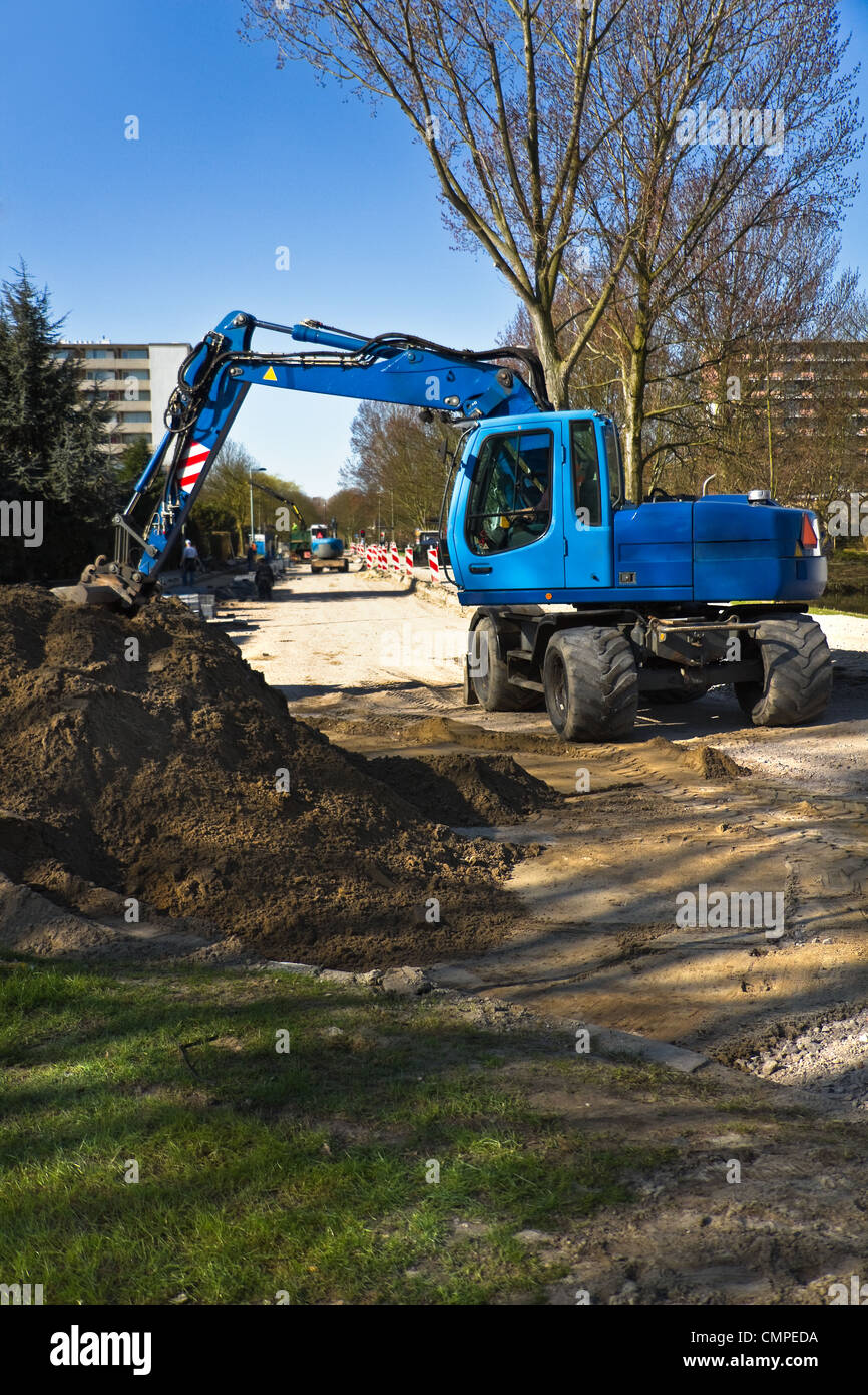 Draglines au travail pour renouveler le revêtement d'une route dans la ville. Les excavatrices et bleu ciel bleu au début du printemps. Banque D'Images