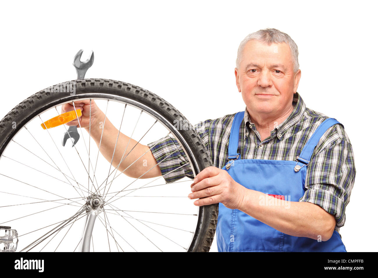 Homme d'âge moyen et la réparation de clé de roue de vélo isolé sur fond blanc Banque D'Images