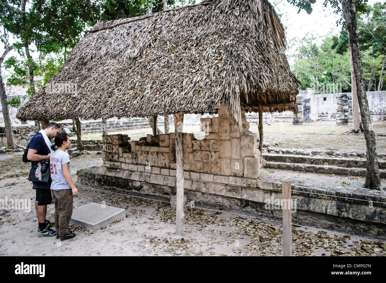 CHICHEN ITZA, Mexique - les touristes à la recherche de quelques pierres sculptées qui sont des vestiges du palais de la colonnes sculptées à la Zone archéologique de Chichen Itza au Mexique. Banque D'Images