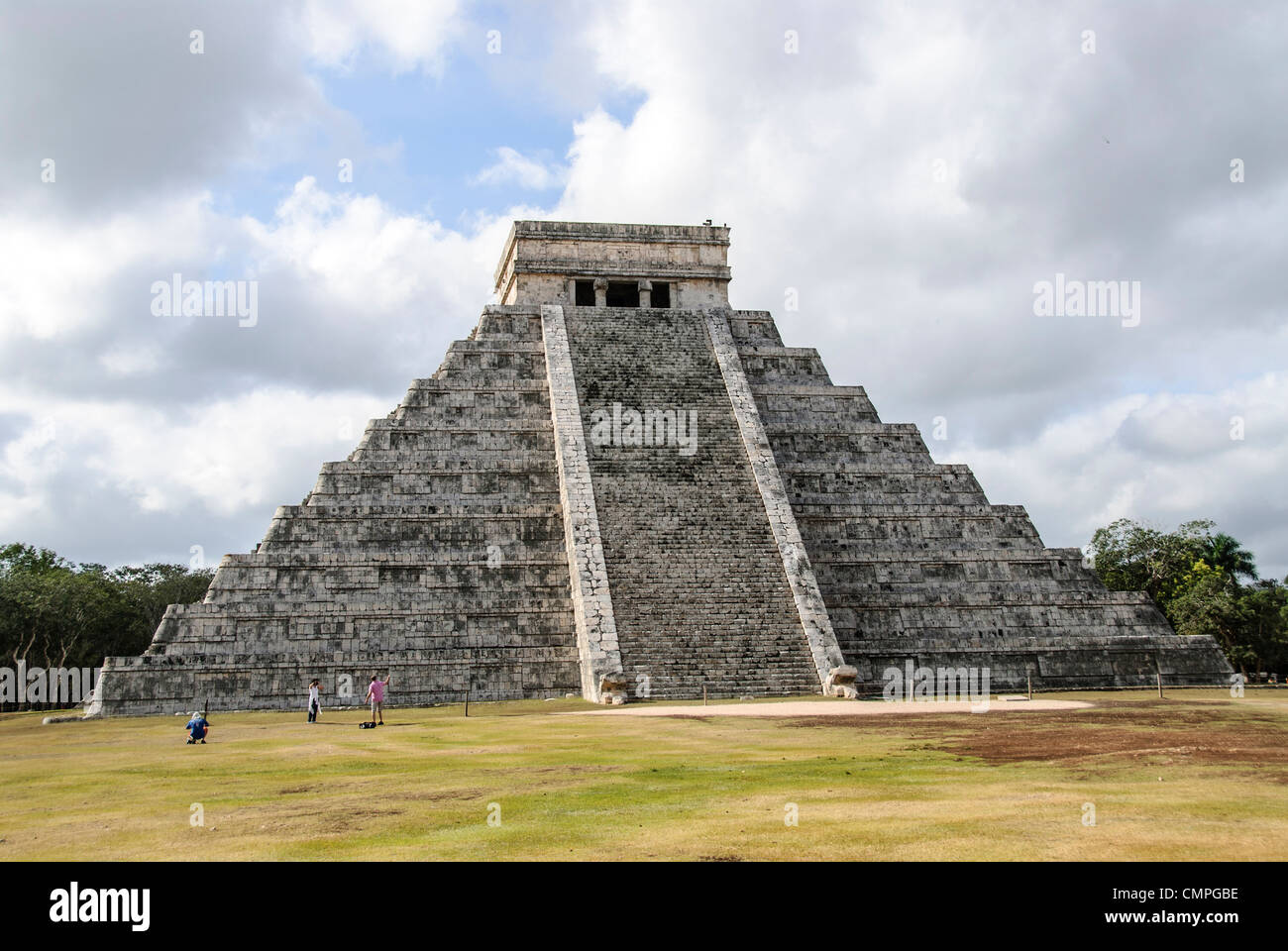 CHICHEN ITZA, Mexique - Touristes debout devant le Temple de Kukulkan (El Castillo) à la Zone archéologique de Chichen Itza, les ruines d'une importante ville de la civilisation Maya au coeur de la péninsule du Yucatan au Mexique. Banque D'Images