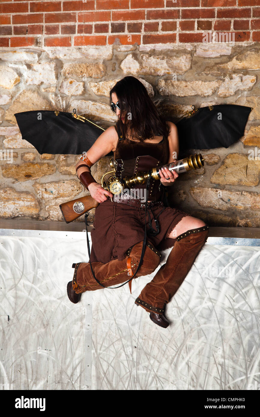 Une pinup girl habillé en costume à thème Steampunk avec des ailes, un jet pack, et d'une carabine Banque D'Images