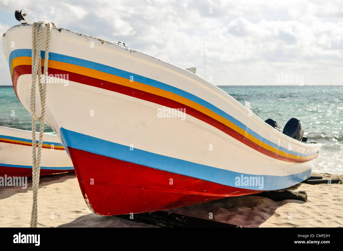 Bateau de pêche sur la plage Playa del Carmen Mexique // Un bateau peint aux couleurs vives s'est arrêté sur la plage de sable de Playa del Carmen sur la péninsule du Yucatan au Mexique. Banque D'Images