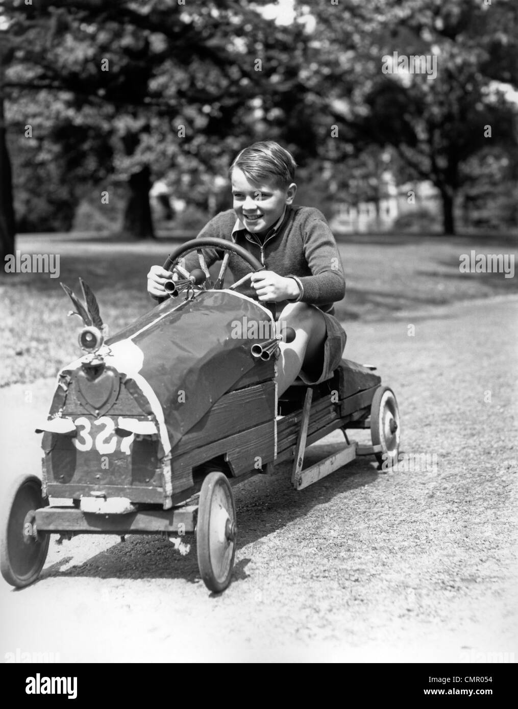 1930 BOY DRIVING HOME CONSTRUIT MAINTENANT LE VOLANT DE VOITURE DE COURSE Banque D'Images