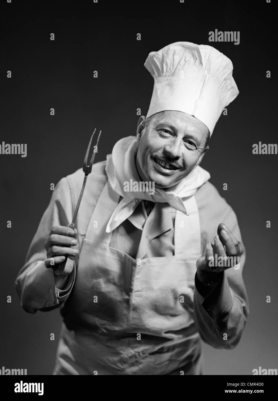 1950 MAN SMILING CHEF AVEC DES MAINS À L'INTÉRIEUR DE L'APPAREIL PHOTO À Banque D'Images