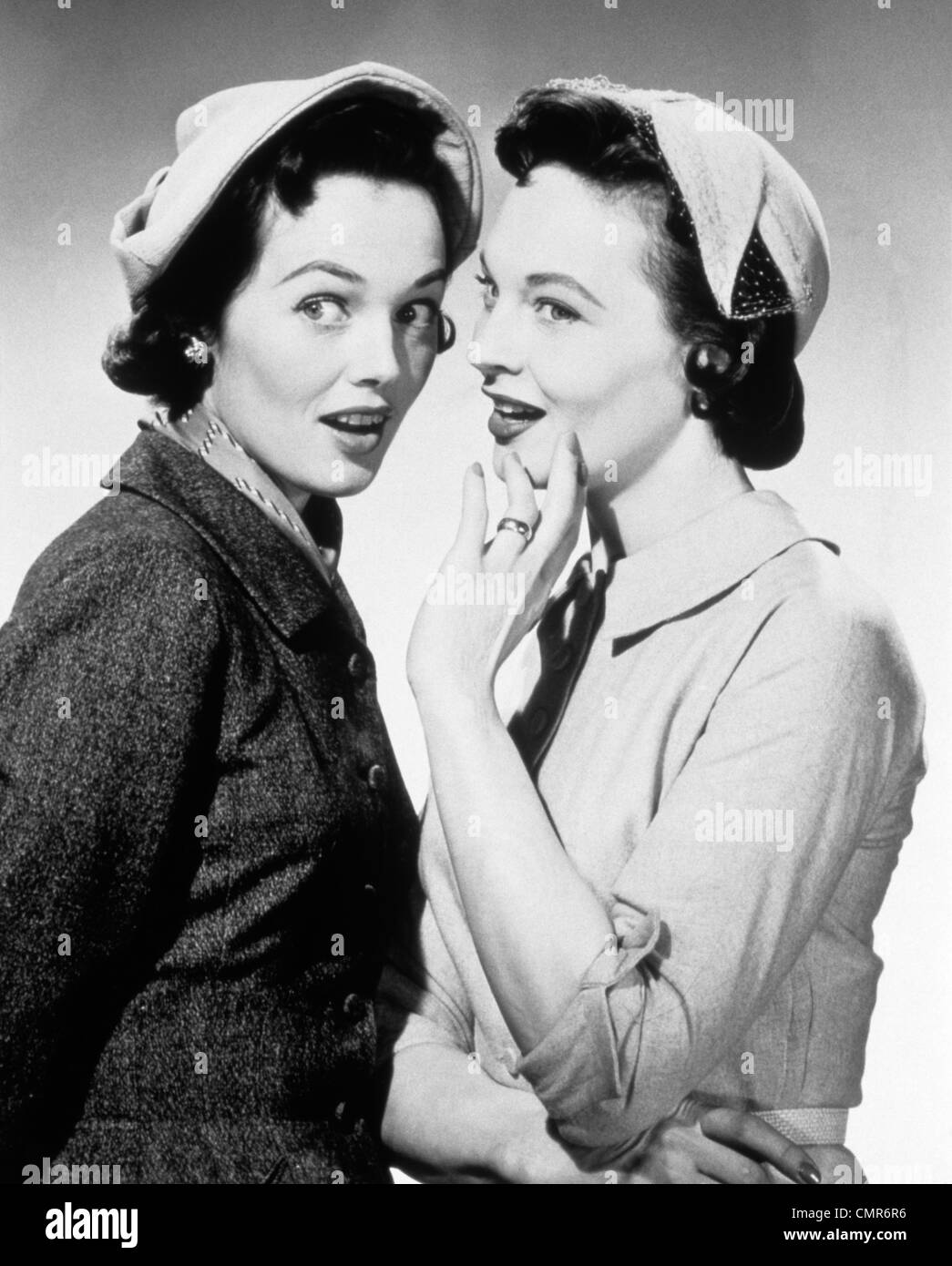 Années 50, deux femmes portant des chapeaux WHISPERING GOSSIP Banque D'Images