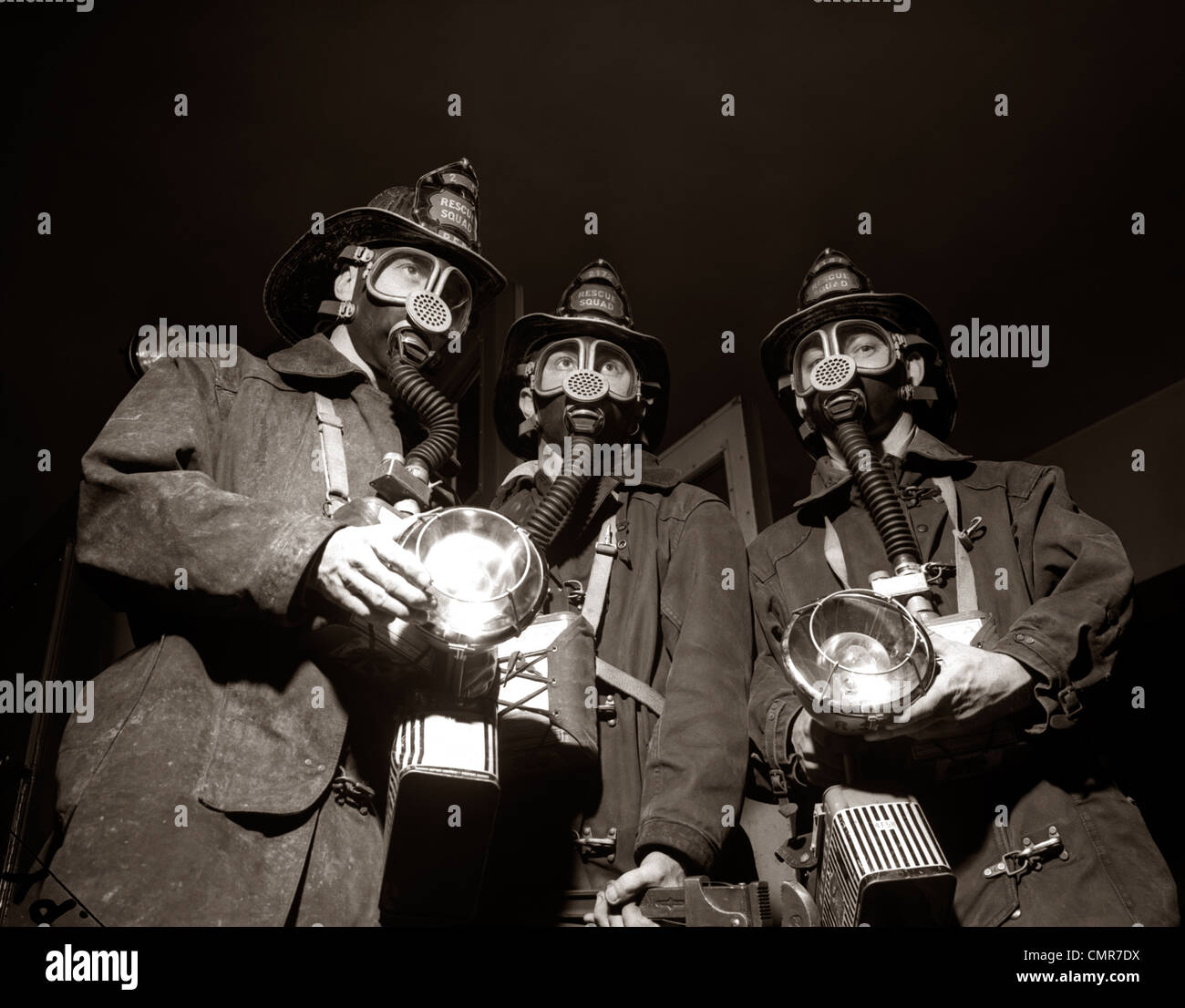 1950 TRIO DE RESCUE SQUAD POMPIERS portant des masques de protection respiratoire porter des lampes de poche ET DU MATÉRIEL D'INCENDIE Banque D'Images