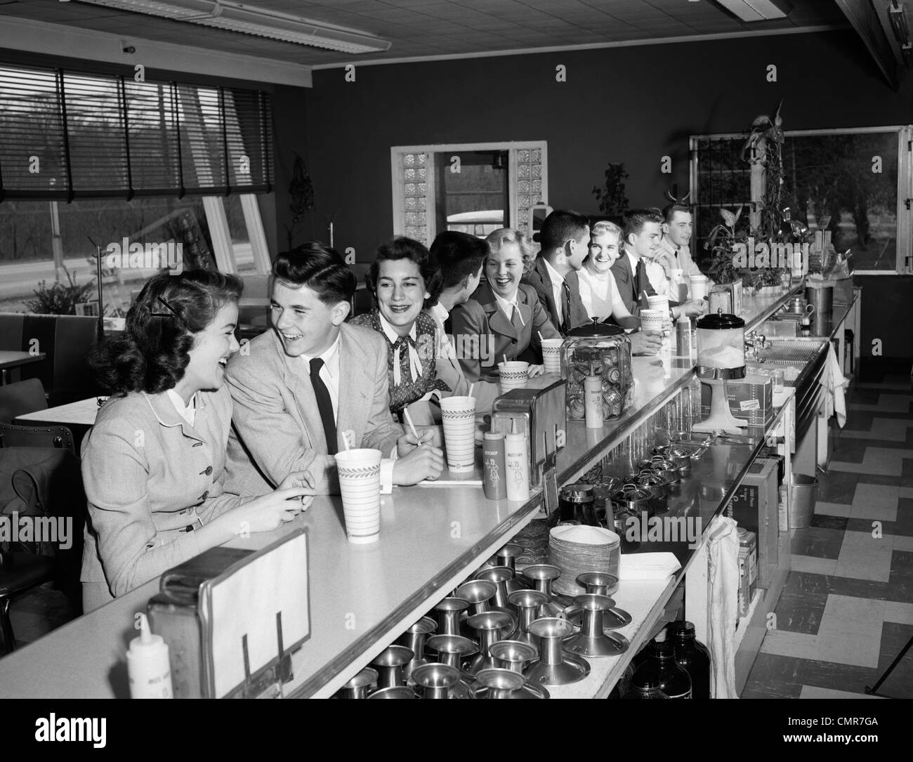 1950 ADOLESCENTS ASSIS À SODA FOUNTAIN COUNTER Banque D'Images