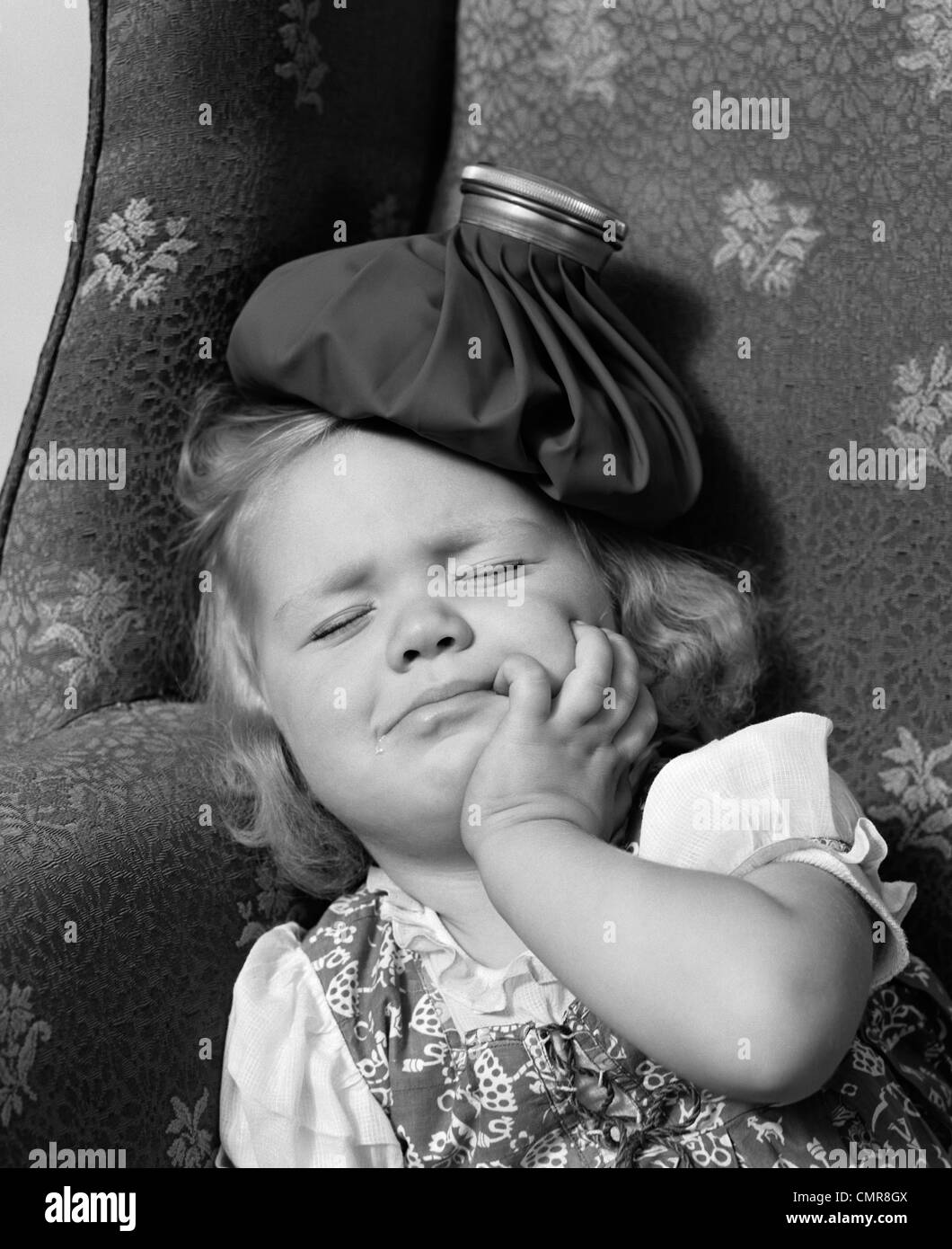 1940 JEUNE FILLE AVEC POCHE DE GLACE SUR LA TÊTE DE DORMIR Banque D'Images