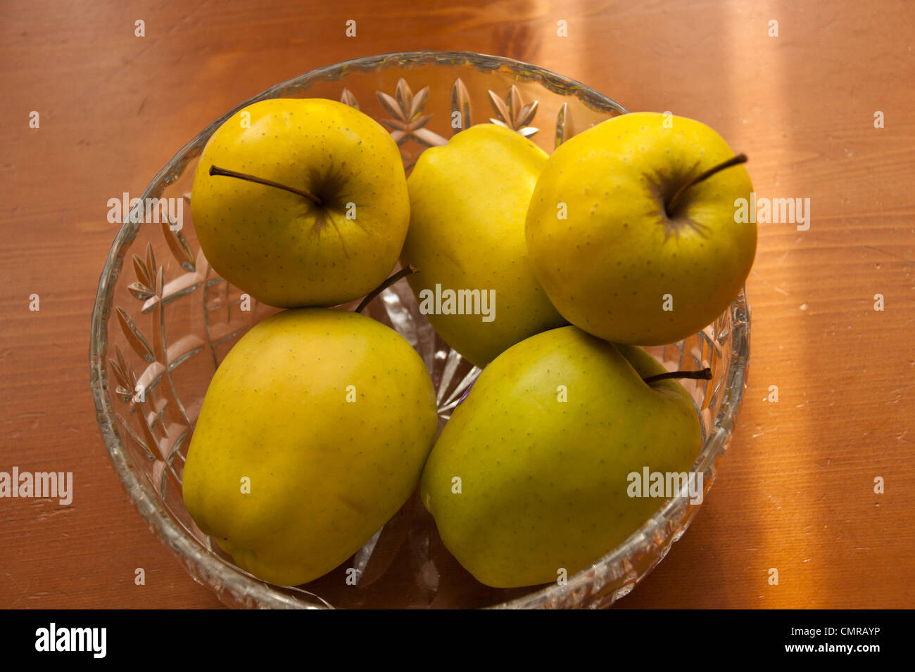 Pommes Golden Delicious dans crystal bol de fruits nature morte. Banque D'Images