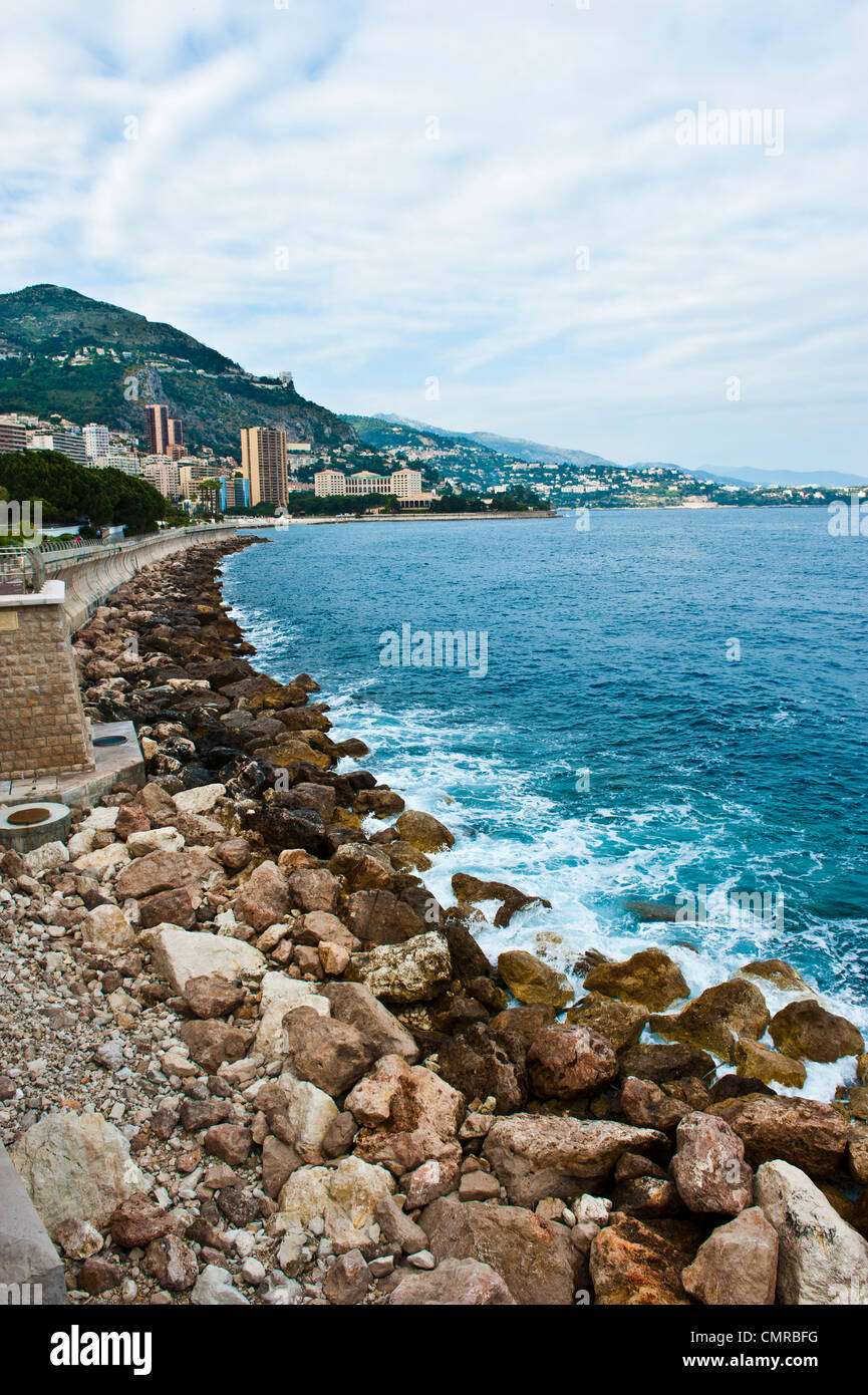 Les algues vertes et les rochers le long de la mer Méditerranée, dans un ciel nuageux surplombant la principauté de Monaco. Banque D'Images
