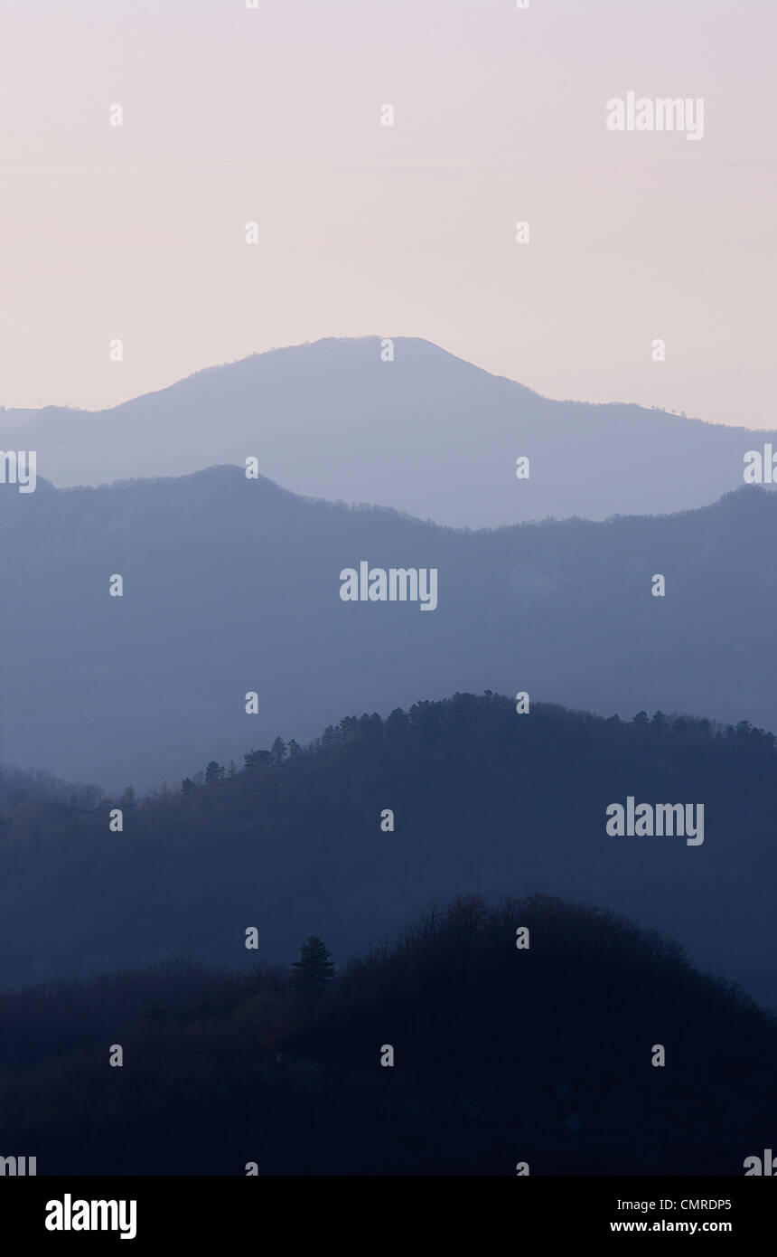 Au coucher du soleil vue collines doucement dégradants de sombre à la lumière bleu dans la brume Banque D'Images