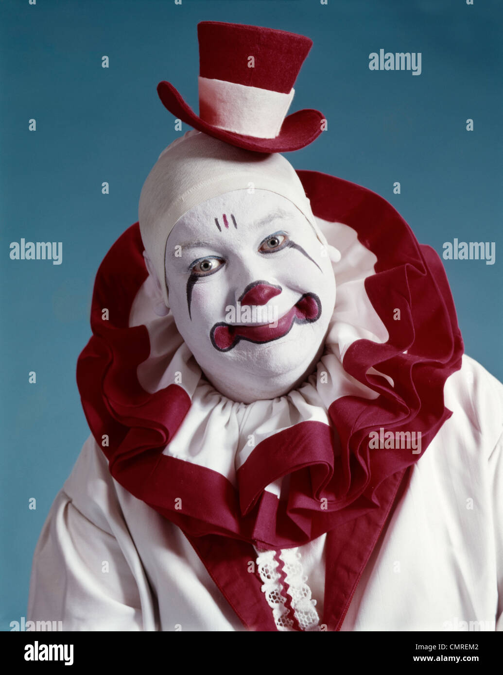 1970 Portrait de clown de cirque EN COSTUME ROUGE ET BLANC, LOOKING AT CAMERA Banque D'Images