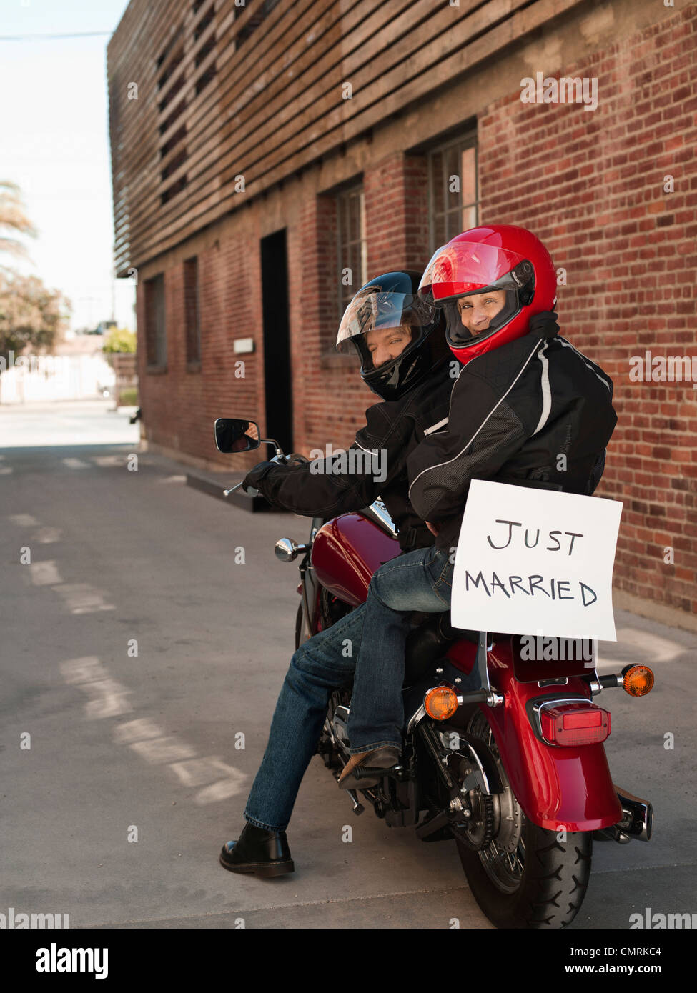 Couple à cheval sur une moto avec juste marié sign Banque D'Images