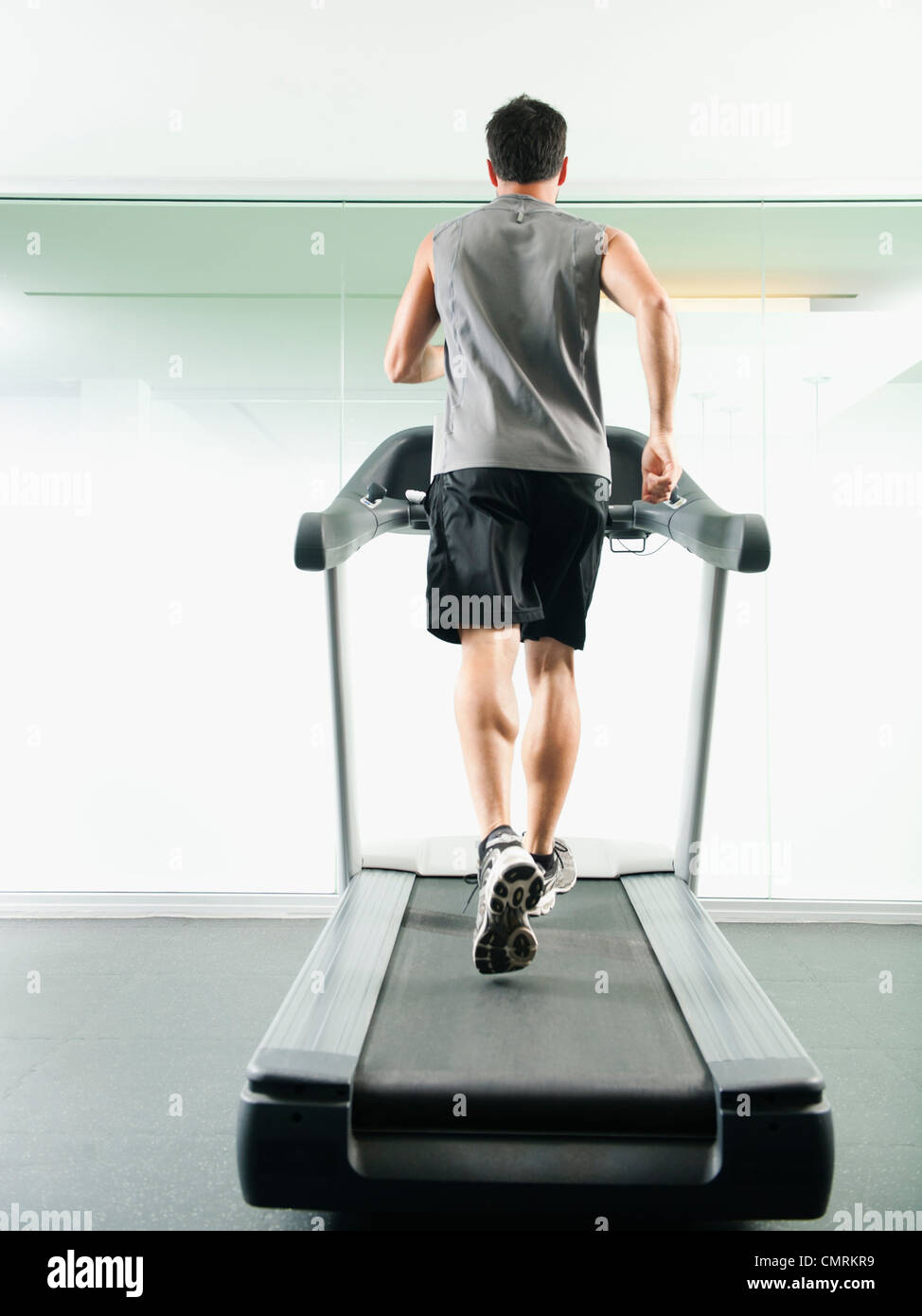 Mixed Race man running on treadmill Banque D'Images