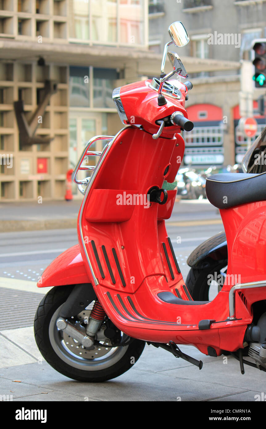 Scooter rouge garée dans la rue de la ville Banque D'Images