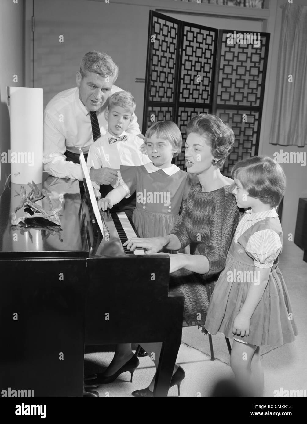 1960 CHANT PIANO DEBOUT AUTOUR DE LA FAMILLE Banque D'Images