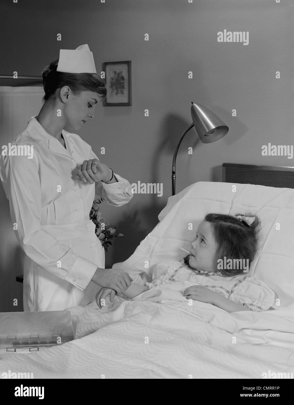 1960 FEMME NURSE CHECKING PULSE DE PRENDRE LA TEMP RATURE SUR LA PETITE 1960 FEMME NURSE CHECKING PULSE DE PRENDRE LA TEMP RATURE SUR LA PETITE