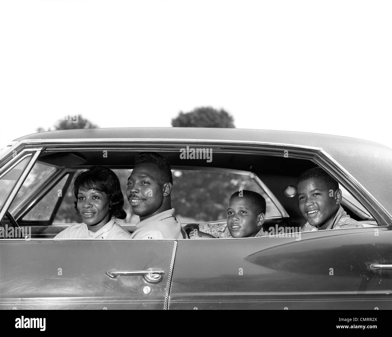 1960 vue côté piscine SMILING AFRICAN-AMERICAN FAMILY PÈRE MÈRE DEUX FILS ASSIS À QUATRE PORTES · AUTOMOBILE Banque D'Images