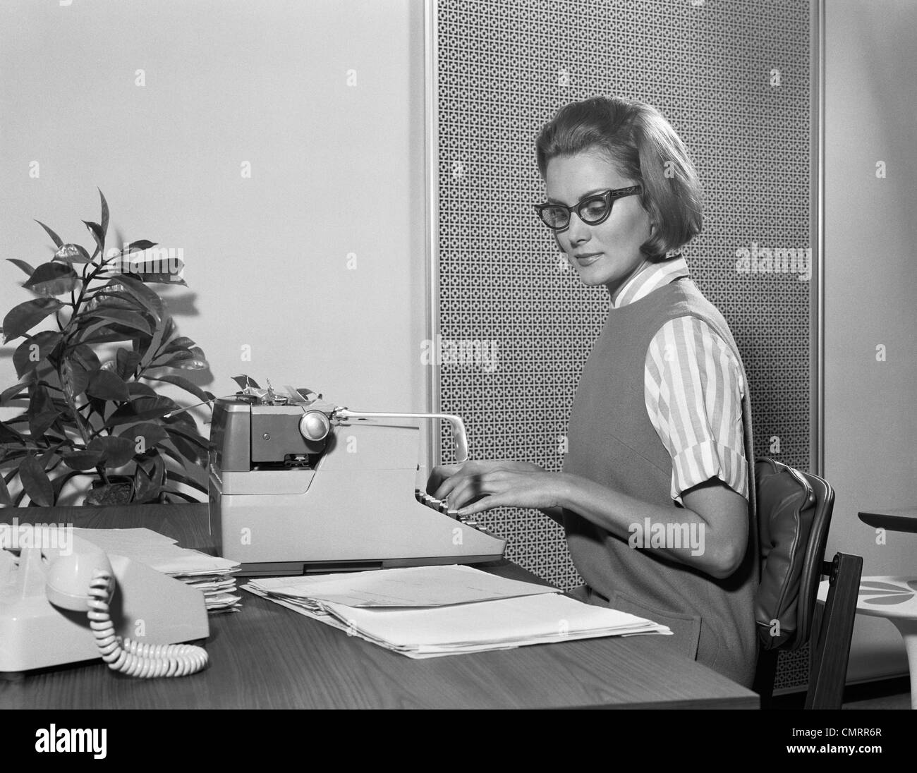 1960 secrétaire dactylographe portant des lunettes élégantes à l'AIDE DE  MACHINE À ÉCRIRE MANUELLE À 24 Photo Stock - Alamy