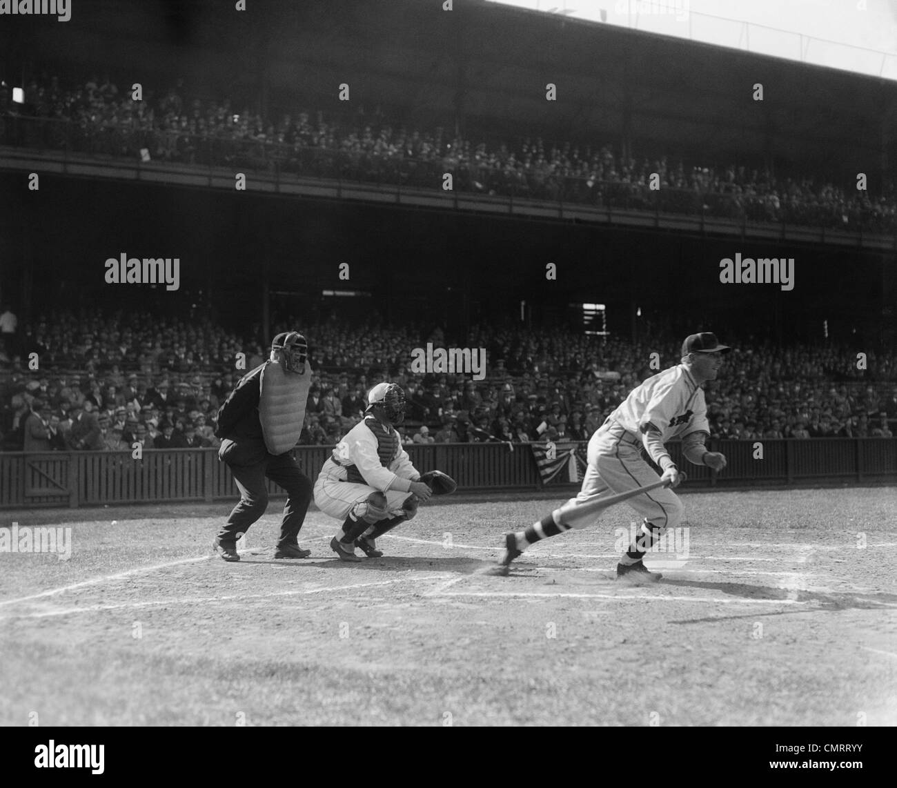 1930 MATCH DE BASEBALL BATTER À PROPOS DE FONCTIONNER APRÈS AVOIR FAIT UN HIT Banque D'Images