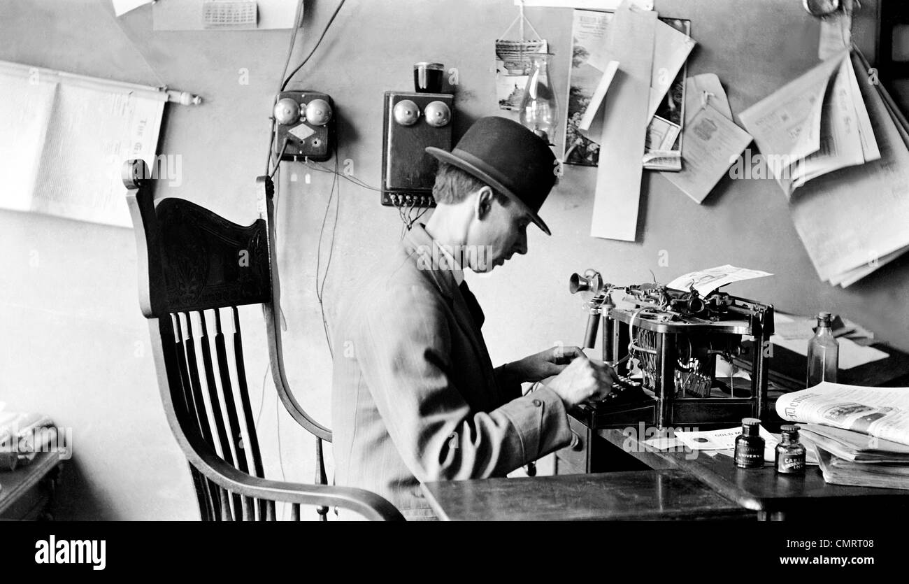 Années 1900 HOMME PORTANT CHAPEAU MELON TAPANT IN OFFICE Photo Stock - Alamy