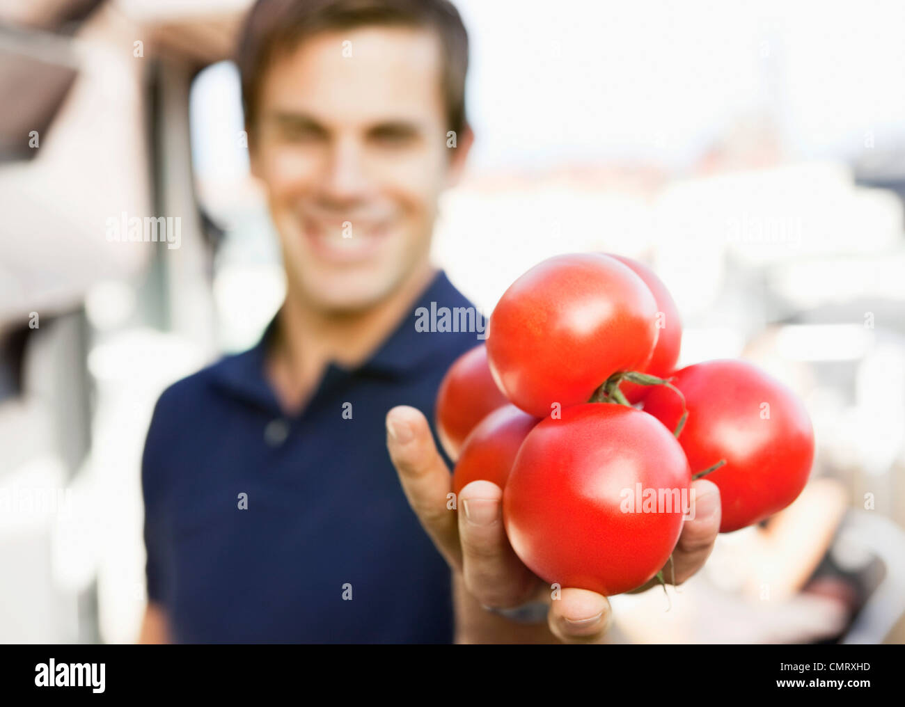 MAn holding tomatoes Banque D'Images