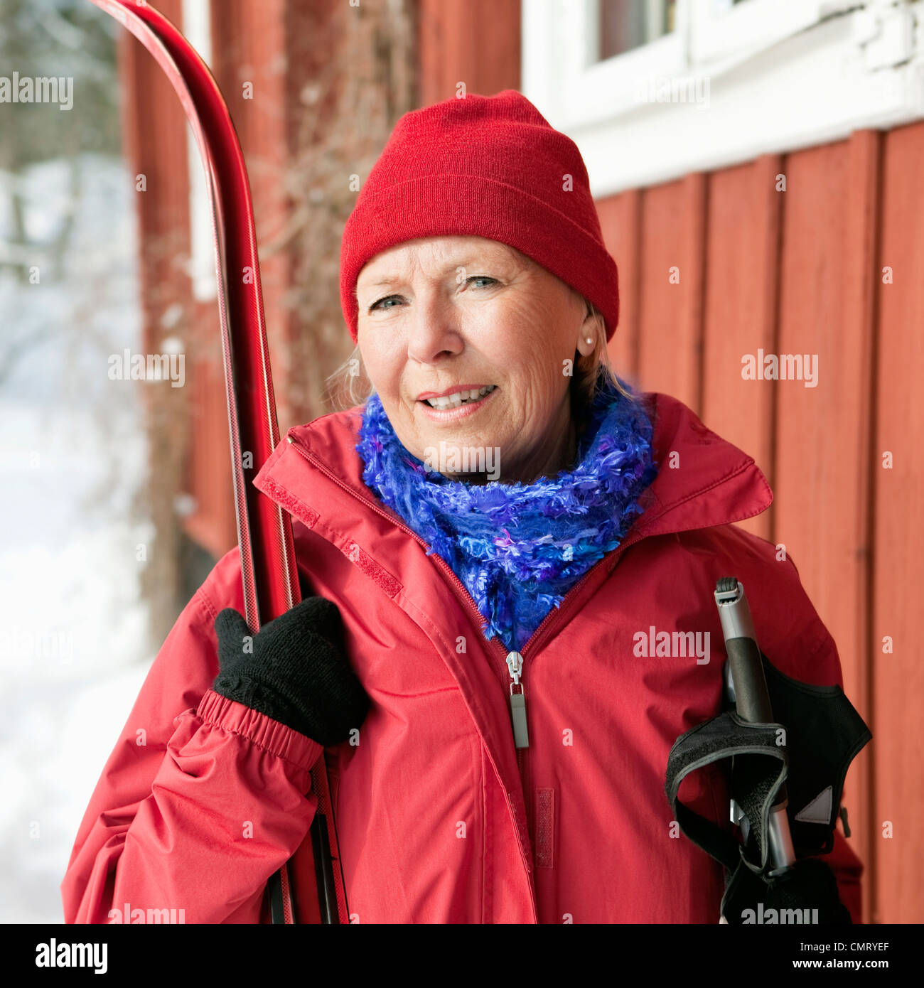 Femme debout à l'extérieur tenant ses skis Banque D'Images
