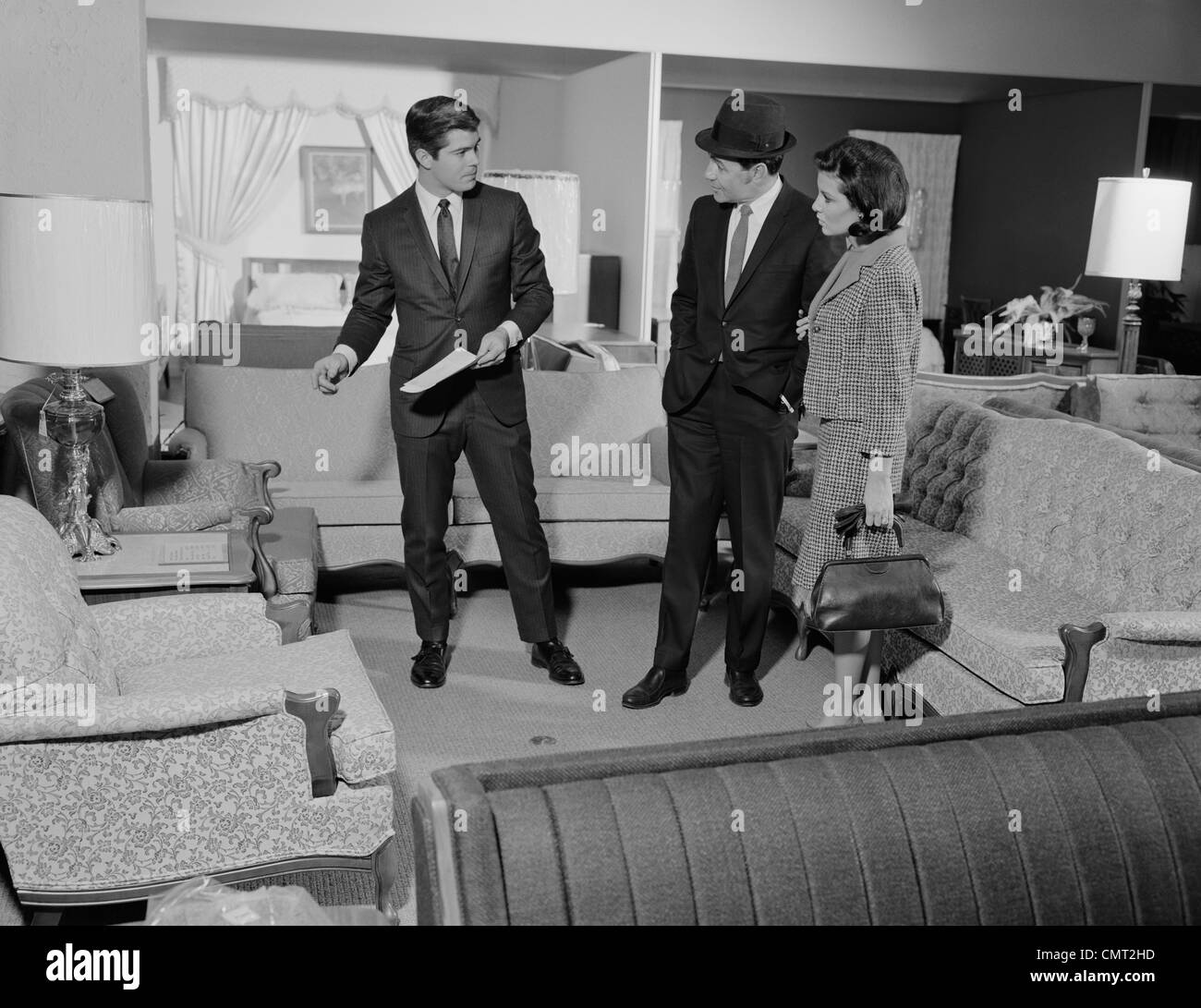 1960 Magasin de meubles SALESMAN TALKING TO COUPLE Banque D'Images