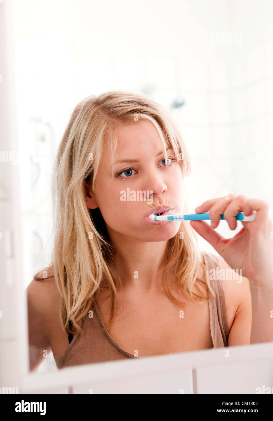 Femme debout dans la salle de bain se brosser les dents Banque D'Images