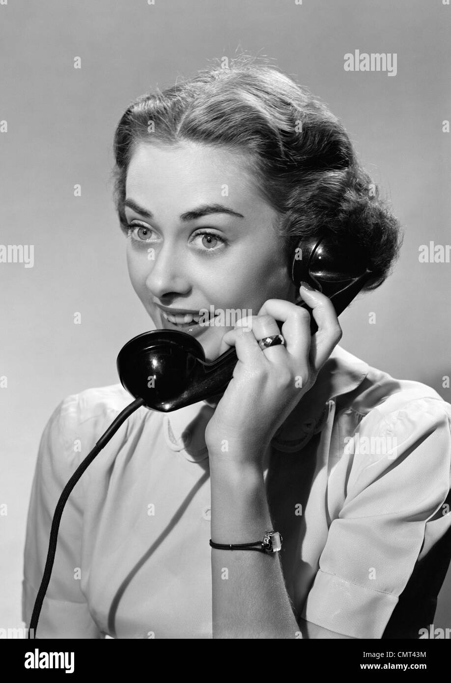 1950 SMILING WOMAN TALKING ON TELEPHONE Banque D'Images