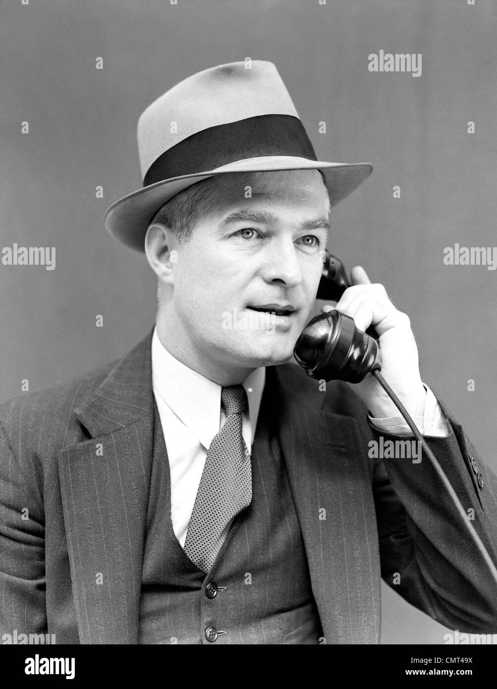1930 1940 MAN WEARING HAT & Costume Cravate et veste en conversation sur  téléphone EXPRESSION GRAVE MAN PORTRAIT Photo Stock - Alamy