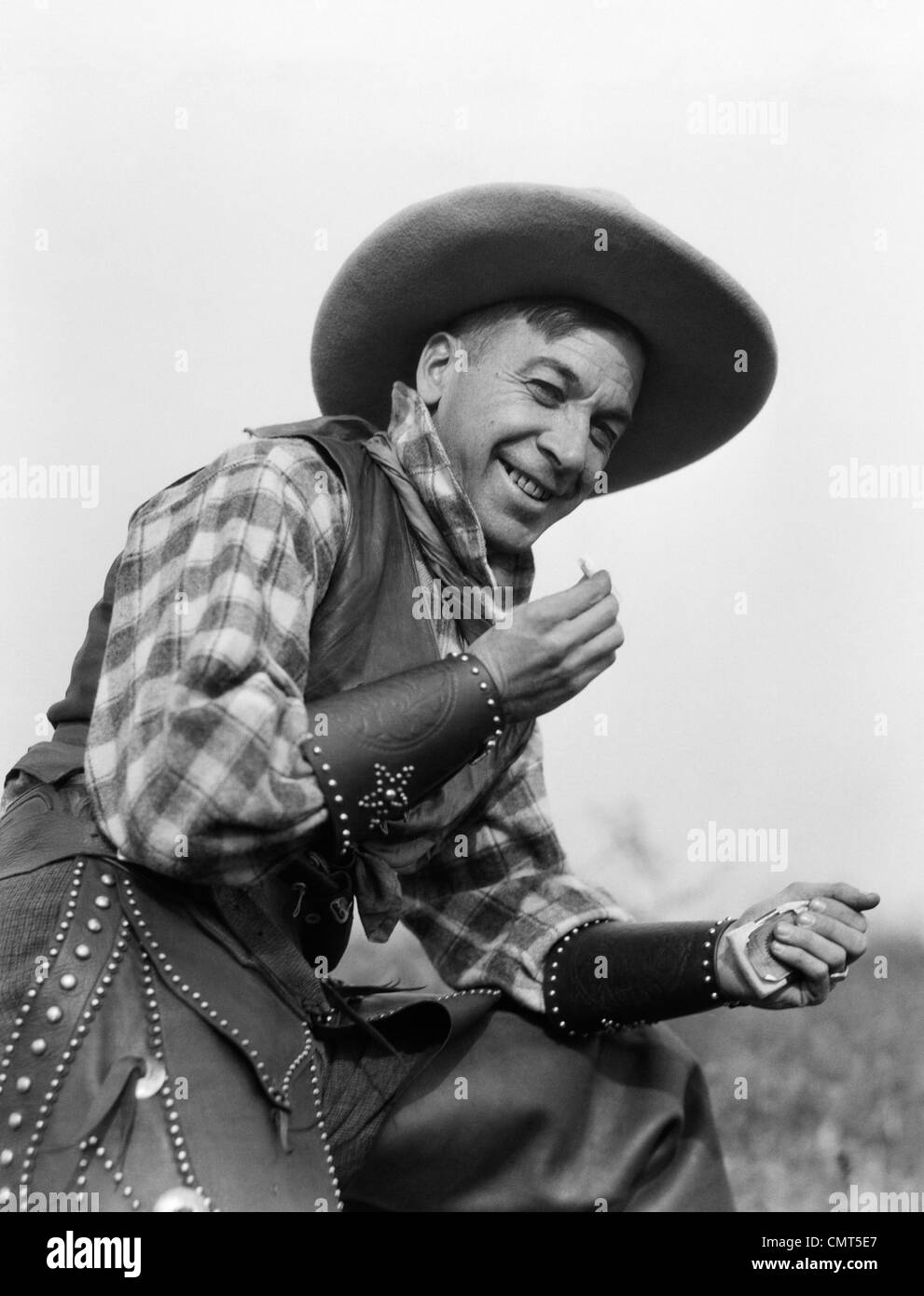 Années 1920 SMILING MAN IN COWBOY HAT VEST manches et pantalon cigarette ROULANT Banque D'Images