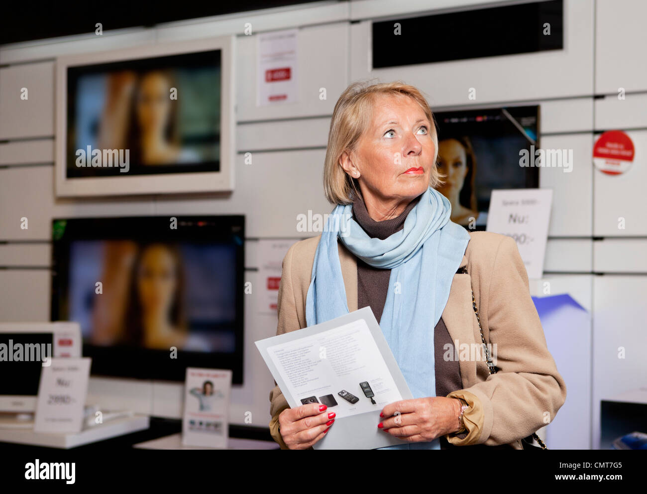 Woman holding brochure de produits à plat store Banque D'Images