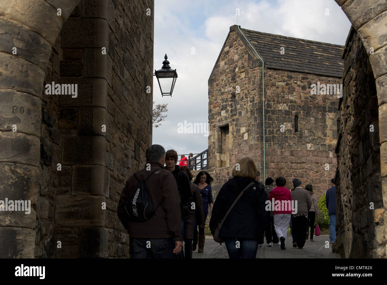 Les touristes de passage à travers un passage étroit entre un certain nombre de vieux bâtiments historiques à l'intérieur du château d'Édimbourg Banque D'Images