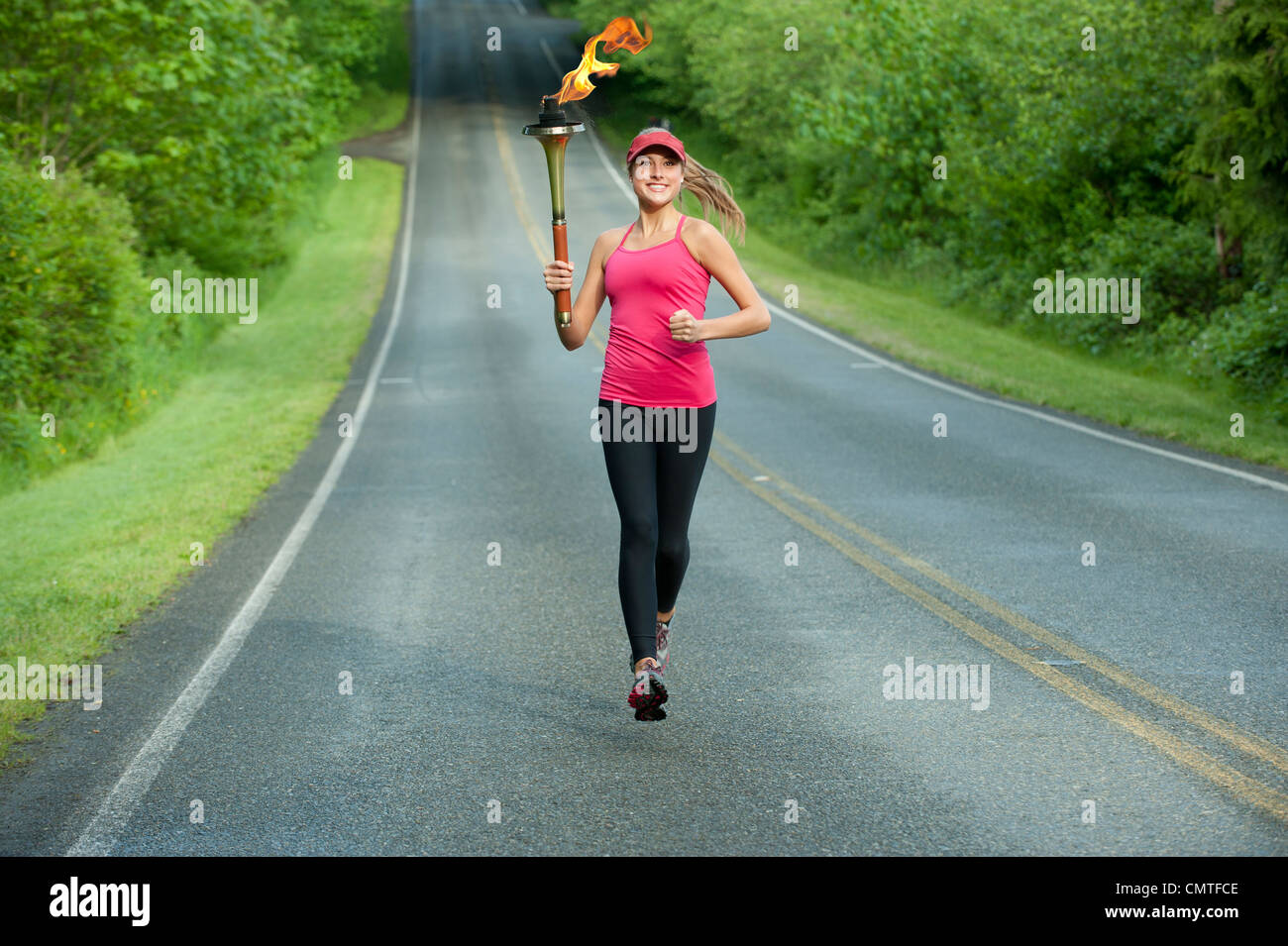 L'athlète de race blanche tournant avec torche olympique sur route à distance Banque D'Images