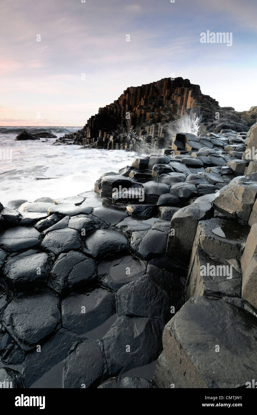 Le ciel au-dessus de ciel coucher de colonnes de basalte de forme hexagonale Giant's Causeway le comté d'Antrim en Irlande du Nord Banque D'Images