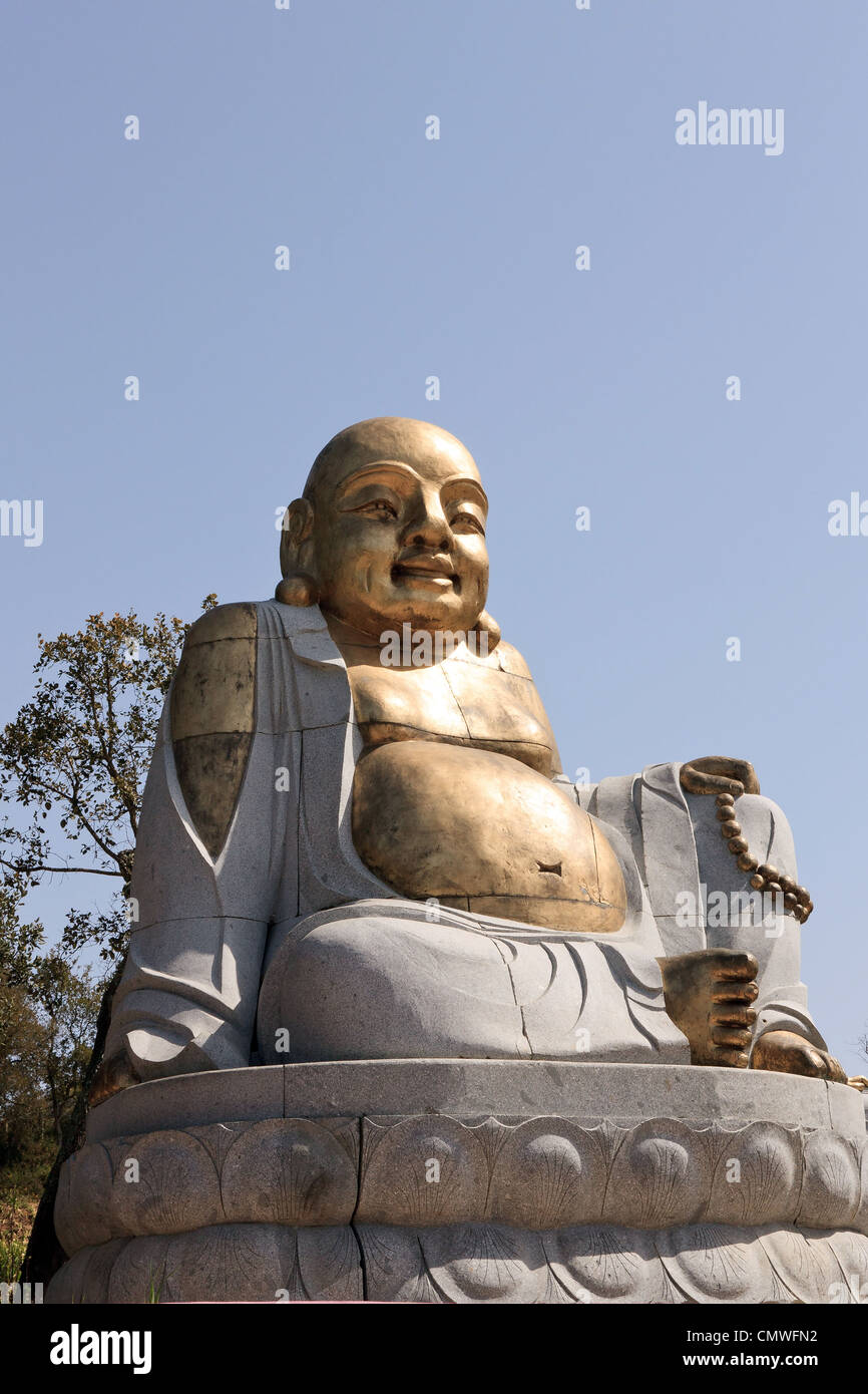 Statue de Bouddha en bronze smiley exposés dans un jardin public Banque D'Images