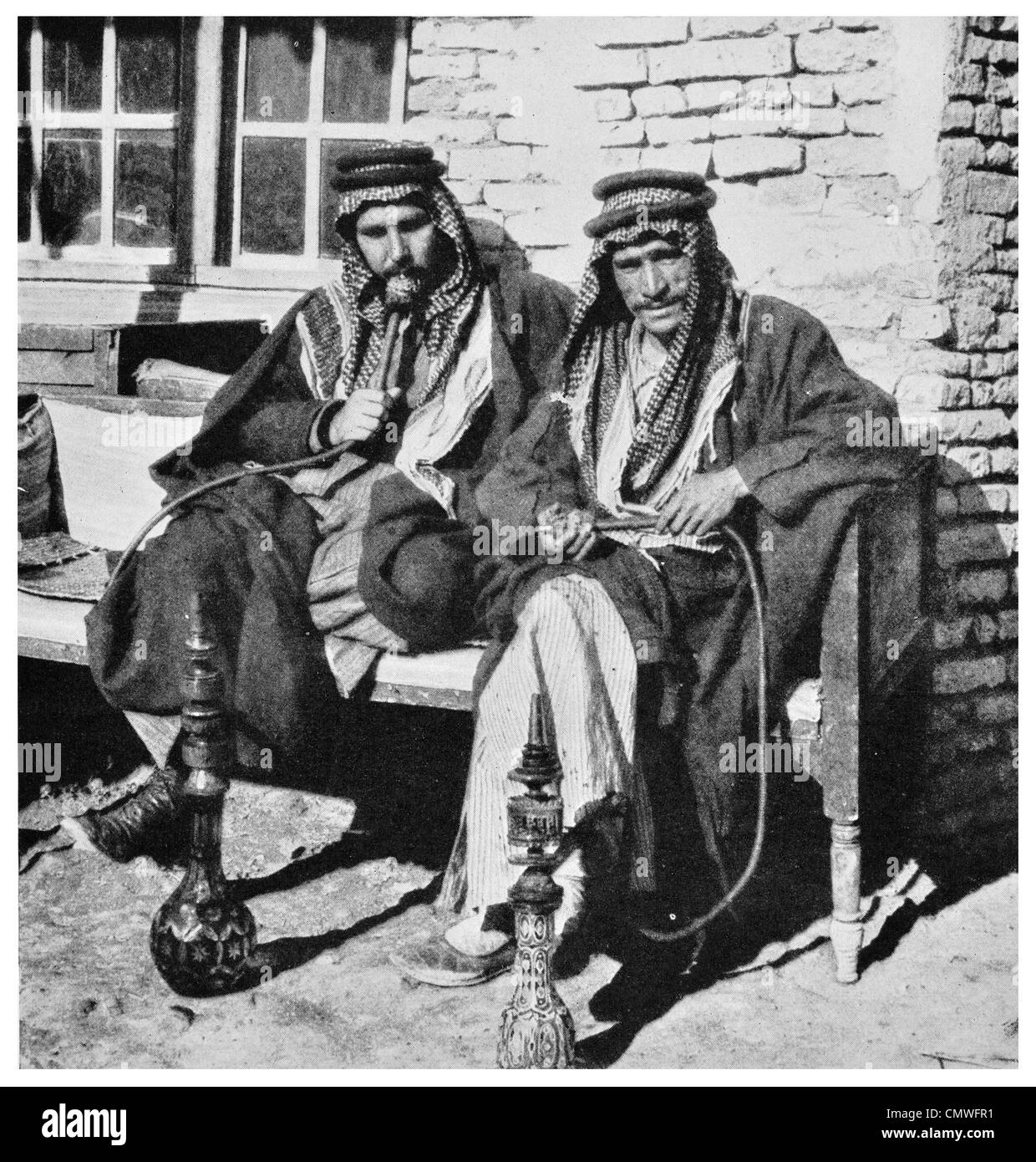 Les Arabes du désert 1925 de haut degré de fumer la pipe de l'eau café narguilé Banque D'Images