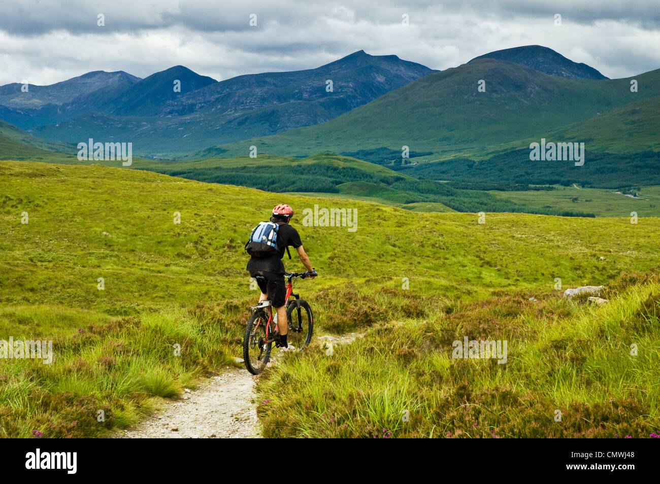 Le vélo de montagne sur le West Highland Way en Écosse, les pics de la montage à l'arrière noir Banque D'Images