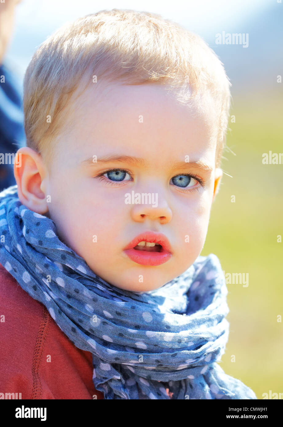 Portrait de triste et grave petit bébé garçon au printemps. Banque D'Images