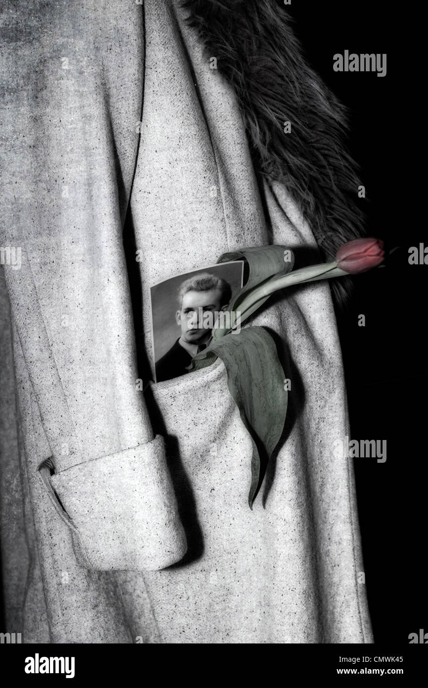 Un manteau à col de fourrure qui pèsent sur une chaise, dans la poche d'une photo d'un homme et d'une tulipe Banque D'Images