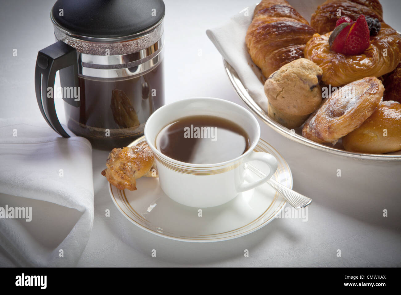 Petit-déjeuner tasse de café et cafetière à blanc et avec des pâtisseries , disposés sur une nappe de lin blanc Banque D'Images