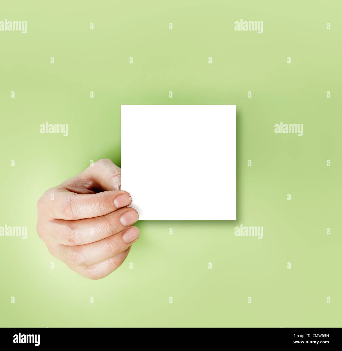 Une main tenant un vide remarque sur fond vert. Banque D'Images