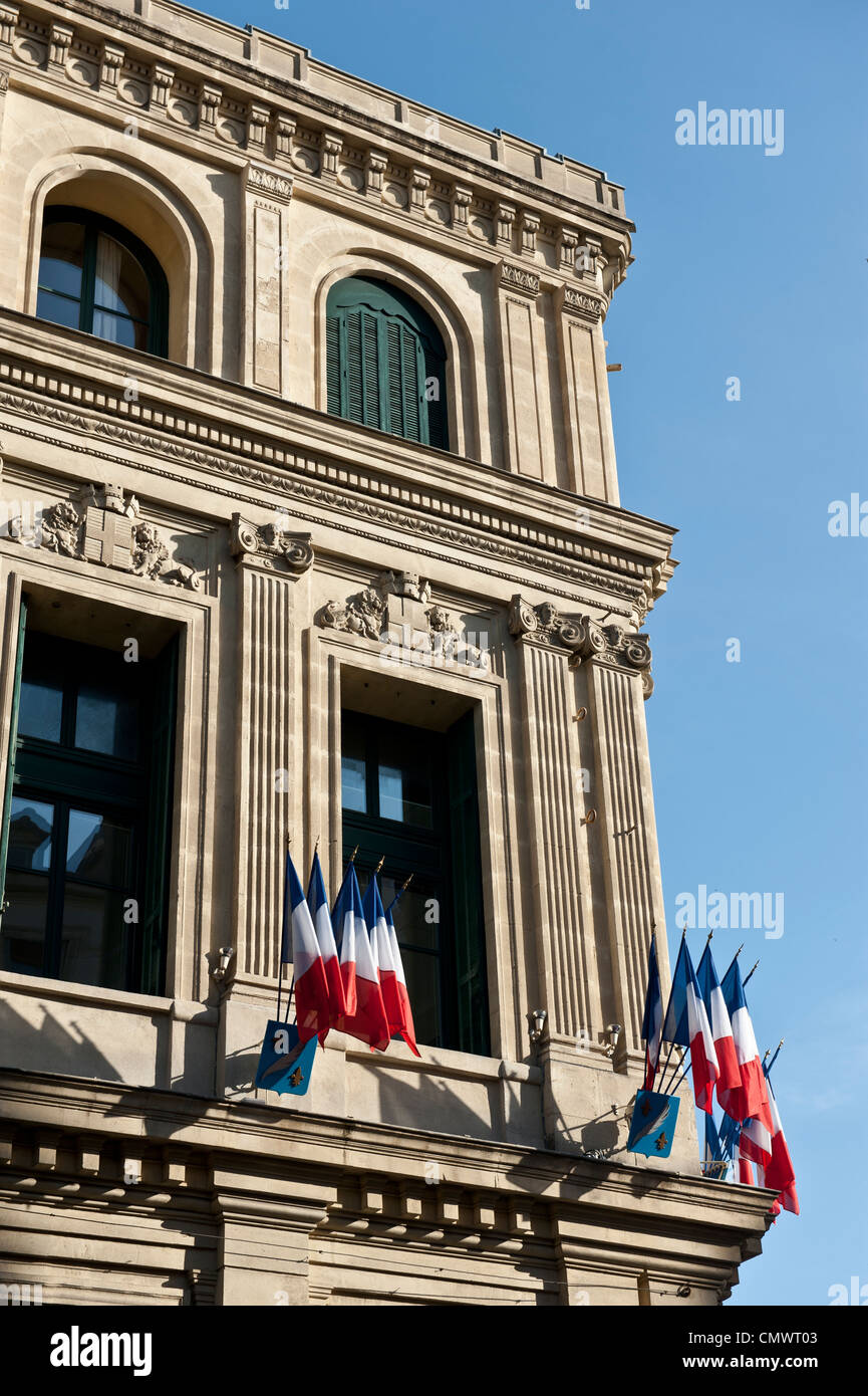 Drapeaux français posté sur un rebord de l'angle d'un bâtiment brun sable. Banque D'Images