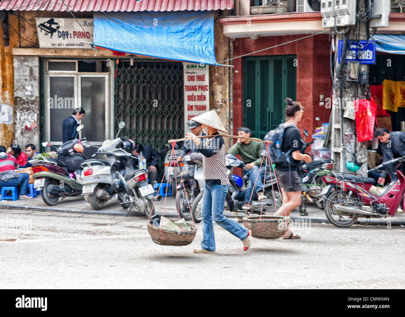 Vendeurs de nourriture transporter transporter personnes street road ville marchandises suspendus paniers légumes frais produits vietnamiens vietnam hanoi sel Banque D'Images