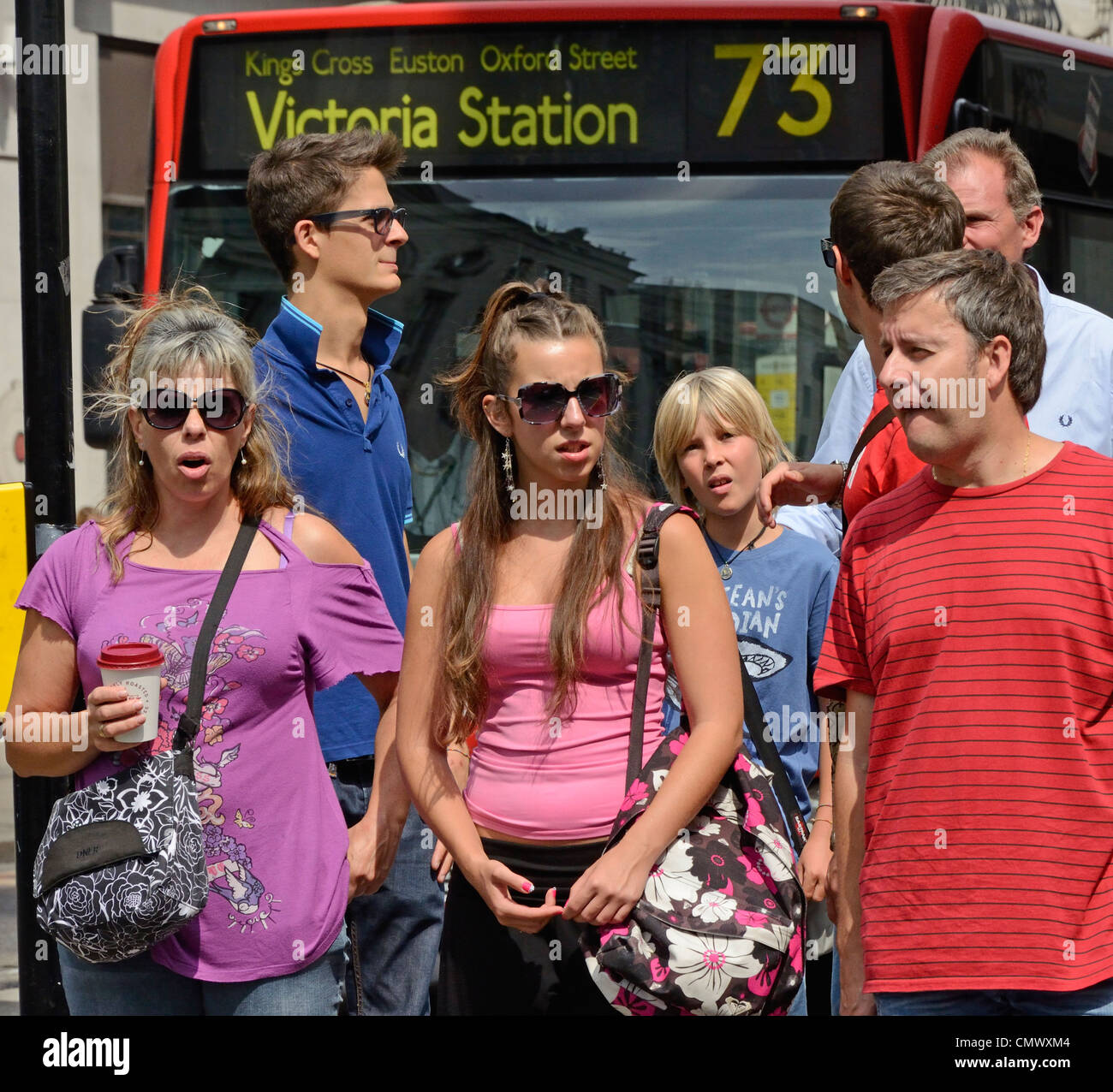 Londres, Angleterre. personnes attendant de cross street / red bus Banque D'Images