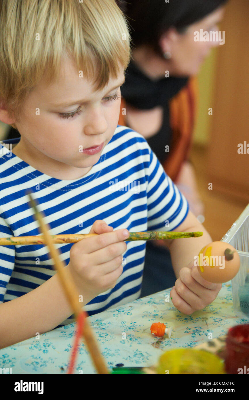 Garçon enfant peinture et décoration d'oeufs de pâques Banque D'Images