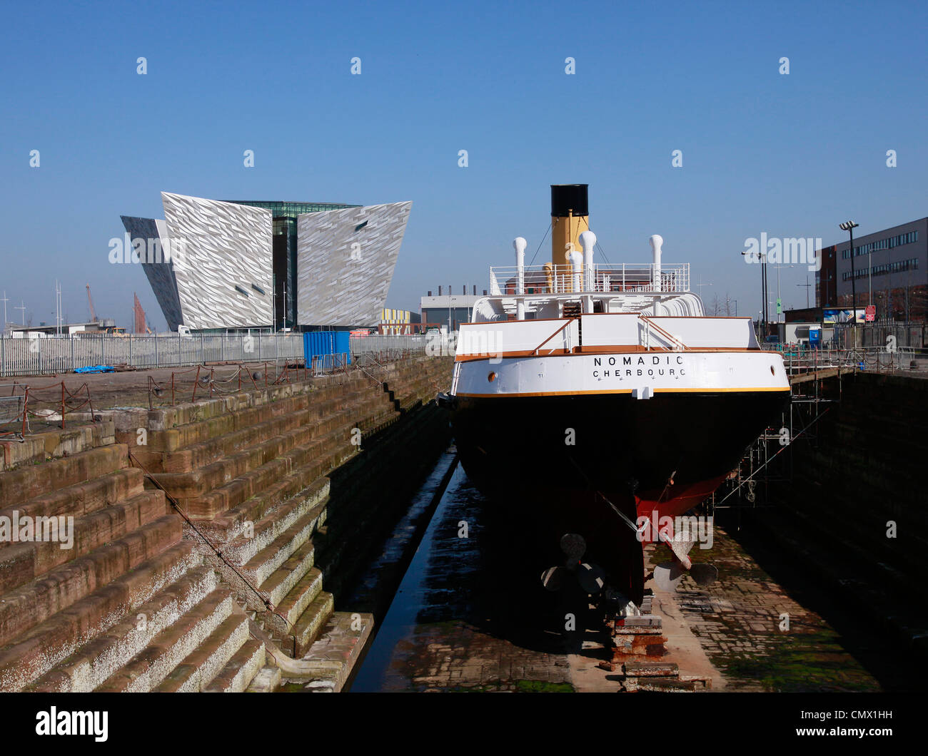 Le navire nomades se trouve en cale sèche avec le Titanic visitor centre à l'arrière-plan à Belfast, en Irlande du Nord Banque D'Images